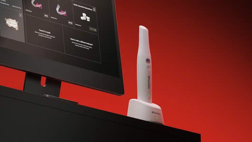 SprintRay Foundation intraoral scanner in its charging dock beside a monitor running SprintRay scan software